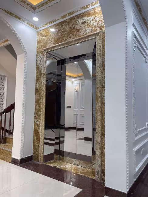 Cửa tầng thang máy inox gương ốp đá vàng phong cách tân cổ điển do Tân Tiến lắp đặt